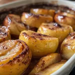 Side view of a serving of baked apples topped with cinnamon.