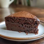 Juicy slice of chocolate cake showcasing layers and a shiny chocolate glaze.