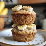 Juicy gluten-free banana oat muffins displayed on a rustic wooden background.