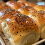 Appetizing Greek yogurt rolls stacked on a plate, highlighting their golden crust and fluffy inside.