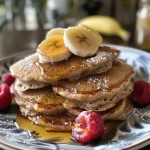 Delicious oatmeal pancakes arranged neatly on a plate, garnished with fresh fruit.