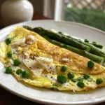 Juicy spring omelet showcasing bright green peas and asparagus with golden-brown edges.