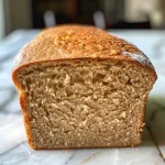 Juicy whole wheat sandwich bread with a soft interior and crunchy seeds on top.