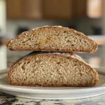 Side view of freshly baked whole wheat sourdough sandwich bread with a golden crust.