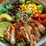 Close-up view of a colorful chicken and quinoa dinner bowl with vibrant ingredients.