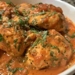 Side view of slow cooker creamy tomato basil chicken, showcasing its rich texture and vibrant color.
