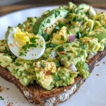Juicy avocado egg salad on whole-grain bread, highlighted by a dash of smoked paprika.