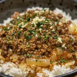 A close-up view of a Beefy Garlic Butter Bowl, showcasing ground beef mixed with rice and melted cheese.