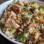 Close-up of a plate of Chicken Pulao with garnishes, showcasing juicy pieces of chicken and rice.