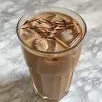 Close-up of a Chocolate Cream Cold Brew in a glass with ice and chocolate drizzle.