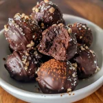 Close-up of dark chocolate avocado truffles, showcasing a rich, glossy exterior and a smooth interior.