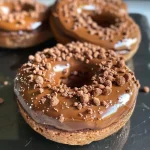 Juicy, chocolate-covered protein donut displayed on a plate.