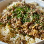 Close-up view of Garlic Butter Beef and Rice with melted cheese on top.