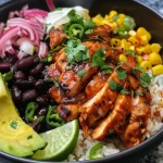 Detailed shot of a rice bowl showcasing honey chipotle chicken, avocado, and lime.