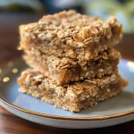 Close-up of Honey Coconut Oat Bars with a golden-brown top and sprinkled coconut flakes.