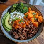 Close-up view of a bowl filled with Hot Honey Beef, sweet potato, and avocado.