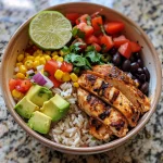 A vibrant Mexican Chicken and Rice Bowl featuring colorful ingredients like chicken, rice, avocado, and cilantro.