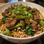 Juicy ramen noodles topped with thinly sliced beef and vibrant greens, showcasing chili oil.