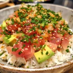 Detailed shot of Spicy Tuna Crispy Rice with finely chopped tuna, avocado slices, and jalapeño.