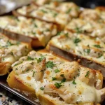 ['Close-up of Chicken Alfredo Garlic Bread topped with melted cheese and parsley.', 'Side view of a loaf of Chicken Alfredo Garlic Bread with juicy chicken and garlic butter.', 'Appetizing Chicken Alfredo Garlic Bread, showcasing its gooey cheese and crispy crust.', 'Deliciously presented Chicken Alfredo Garlic Bread with a golden crust and creamy filling.']