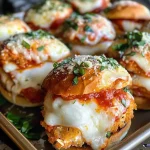 ['Close-up view of juicy Chicken Parmesan Sliders with melted cheese and marinara.', 'Side view of Chicken Parmesan Sliders on Kings Hawaiian rolls, garnished with fresh herbs.', 'Delicious Chicken Parmesan Sliders featuring golden-brown chicken and layered cheese.', 'Tempting Chicken Parmesan Sliders displaying rich marinara sauce and fresh basil.']