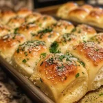 ['Close-up view of golden-brown garlic Parmesan dinner rolls with a soft texture.', 'Side view of fluffy garlic Parmesan rolls, showcasing melted butter and herbs on top.', 'Juicy garlic Parmesan dinner rolls arranged on a plate, highlighted by a warm glow.', 'Freshly baked dinner rolls with a sprinkle of Parmesan and garlic, capturing their golden crust.']
