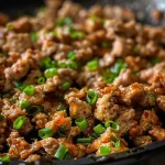 ['Close-up view of a plate featuring honey garlic ground turkey, garnished with green onions.', 'Juicy honey garlic ground turkey served in a bowl, showcasing glistening sauce and fresh herbs.', 'Side view of honey garlic ground turkey with steam rising, highlighting its juicy texture and vibrant colors.', 'Detailed shot of a serving of honey garlic ground turkey, emphasizing the sticky glaze and minced garlic.']