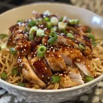 ['Close-up view of a Teriyaki Chicken Noodle Bowl with sliced chicken and vegetables.', 'Side angle shot of Teriyaki Chicken Noodles topped with sesame seeds and scallions.', 'Juicy Teriyaki Chicken served over yaki-soba noodles in a vibrant bowl.', 'Colorful bowl of Teriyaki Chicken Noodles showcasing glazed chicken and fresh garnishes.']
