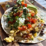 ['Close-up view of a delicious breakfast taco with ingredients displayed.', 'Side view of a juicy breakfast taco filled with eggs and chipotle sour cream.', 'Colorful breakfast taco stacked with refried beans and avocado slices.', 'Tasty breakfast taco topped with creamy chipotle sour cream and cilantro.']