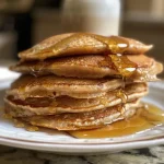 ['Close-up view of fluffy cinnamon honey pancakes, drizzled with honey.', 'Side view of golden brown pancakes with cinnamon and honey, stacked high.', 'A delicious stack of pancakes topped with honey and a sprinkle of cinnamon.', 'Juicy cinnamon honey pancakes displayed with a warm, inviting appearance.']