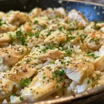['Close-up of Garlic Parmesan Chicken Rice Skillet with diced chicken and rice.', 'Juicy Garlic Parmesan Chicken Rice Skillet featuring parsley garnish on top.', 'Mouthwatering Garlic Parmesan Chicken Rice Skillet showing vibrant ingredients.', 'Side view of a flavorful Garlic Parmesan Chicken Rice Skillet in a skillet.']
