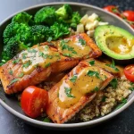 ['Close-up view of a Honey Mustard Salmon Bowl with salmon, quinoa, and vibrant vegetables.', 'Side angle of a colorful Honey Mustard Salmon Bowl featuring fresh ingredients like avocado and cherry tomatoes.', 'Detailed shot of a plated Honey Mustard Salmon Bowl showcasing salmon fillets, green broccoli, and feta cheese.', 'Zoomed-in image of a Honey Mustard Salmon Bowl, highlighting juicy salmon with a drizzle of sauce and garnish.']