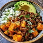 ['Close-up view of a Hot Honey Ground Beef Bowl featuring colorful ingredients.', 'Juicy Hot Honey Ground Beef Bowl with sweet potatoes and avocado in a white bowl.', 'Side view of a delicious bowl filled with ground beef, sweet potatoes, and cottage cheese.', 'A vibrant Hot Honey Ground Beef Bowl topped with avocado and drizzled with hot honey.']