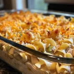 ['Close-up of a turkey noodle casserole with melted cheese on top.', 'Side view of a hearty turkey noodle casserole with crispy cracker topping.', 'Juicy turkey noodle casserole showcasing creamy layers and golden crust.', 'Delicious turkey noodle casserole served in a baking dish with a rich texture.']