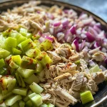 ['Close-up view of a fresh rotisserie chicken salad with vibrant vegetables.', 'Side perspective of a delicious rotisserie chicken salad in a bowl.', 'Juicy rotisserie chicken salad showcasing diced ingredients and creamy dressing.', 'Colorful rotisserie chicken salad featuring shredded chicken and crunchy vegetables.']