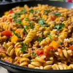 ['Close-up view of creamy cheddar turkey taco pasta with vibrant yellow bell pepper and garnished with cilantro.', 'A side view of a bowl filled with creamy cheddar turkey taco pasta, showcasing the ingredients and texture.', 'Juicy turkey taco pasta dish with melted cheddar cheese, served in a rustic bowl, highlighting colorful diced vegetables.', 'Rich creamy cheddar pasta with ground turkey, diced tomatoes, and a sprinkle of cilantro, captured in natural light.']
