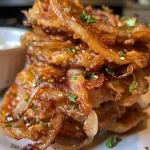 Close-up view of a golden-brown Amish onion fritter, showcasing crispy edges and juicy onions.