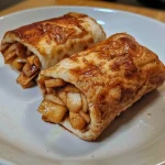 Close-up of Cinnamon Apple Protein Rollups with a golden brown exterior.