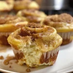 Close-up side view of golden-brown cinnamon roll muffins with swirl patterns.
