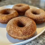Close-up side view of healthy baked apple cider donuts on a plate.