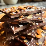 Close-up view of Keto Chocolate Almond Bark with a glossy finish and scattered almonds.