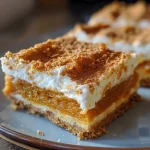Close-up side view of creamy pumpkin roll bars with a soft texture.