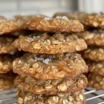 Close-up view of a freshly baked salted caramel oatmeal cookie with a golden-brown color and caramel bits.
